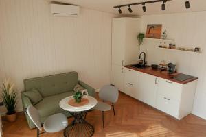 a living room with a couch and a table and a kitchen at Sakų Apartamentai in Varėna