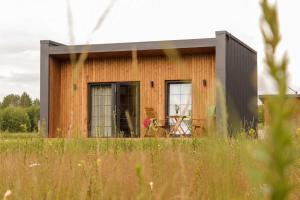 a tiny house in a field of grass at Sakų Apartamentai in Varėna