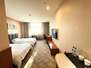 a hotel room with three beds and a television at Dayi Yihao hotel in Xiamen +16 photos
