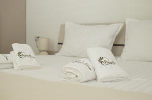 a white bed with towels and pillows on it at Maslina in Crikvenica