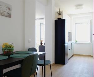 a dining room with a table and a black refrigerator at Maslina in Crikvenica