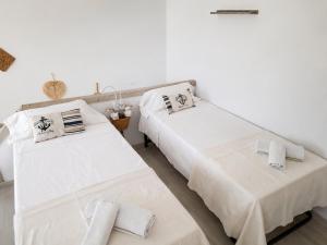 two beds in a room with white walls at EL Niu del Delta in Deltebre