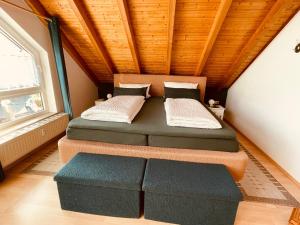 a bedroom with two beds and a ottoman at Ferienwohnung Auf dem Hohen in Hüfingen