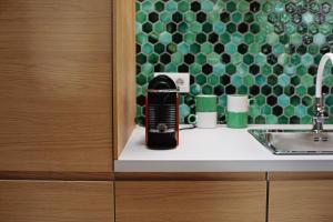 a black appliance sitting on a counter next to a sink at Moft Loft. Lovely, comfy apartment. in Cluj-Napoca
