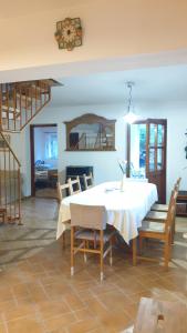 a dining room with a white table and chairs at Winterberg Vendégház in Óbánya