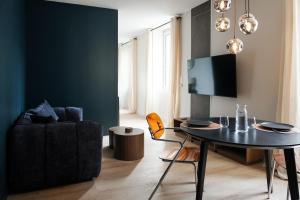 a living room with a table and a couch at La Nuit Etoilee Balneo Hyper Centre Chalon in Chalon-sur-Saône