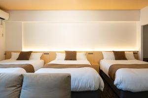 a row of three beds in a room at Residence Hotel KABUTO Premier in Sapporo