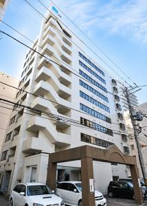 a large white building with cars parked in front of it at Residence Hotel KABUTO Premier in Sapporo +9 photos
