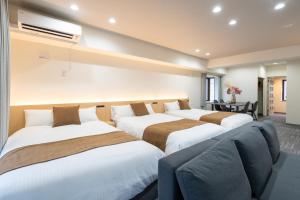 a row of three beds in a room at Residence Hotel KABUTO Premier in Sapporo