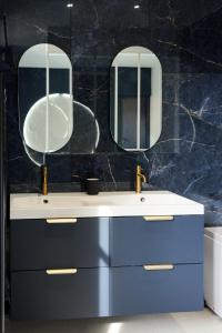 a bathroom with two sinks and two mirrors at La Nuit Etoilee Balneo Hyper Centre Chalon in Chalon-sur-Saône +13 photos