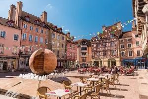 a city square with tables and chairs and a fountain at La Nuit Etoilee Balneo Hyper Centre Chalon in Chalon-sur-Saône