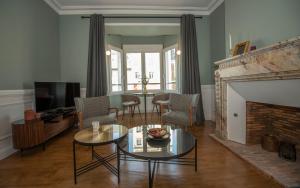 a living room with a table and a fireplace at La Villa du Sillon by les Ambassadeurs - Saint Malo Plage in Saint Malo