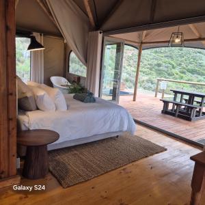 a bedroom with a large bed in a tent at Ontevreden Farm in Montagu