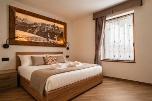 a bedroom with a bed with two towels on it at La Stua de Anny by AMA Val di Fassa in Pozza di Fassa