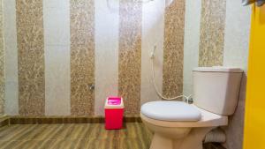 a bathroom with a toilet and a pink trash can at Sayare Inn in Dambulla +64 photos