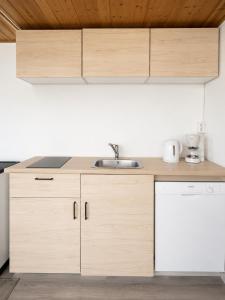 a kitchen with wooden cabinets and a sink at Villa Ralli in Jämsä