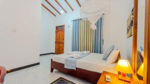 a bedroom with a bed and a table with a lamp at Sayare Inn in Dambulla