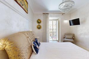 a bedroom with a bed and a television on the wall at B&B Palazzo del Teatro in Agrigento
