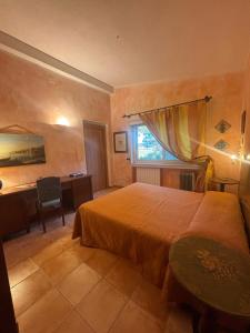 a bedroom with a bed and a desk and a window at Ciuci's Manor in Aragona