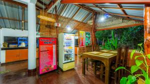 a restaurant with a table and a refrigerator at Sayare Inn in Dambulla