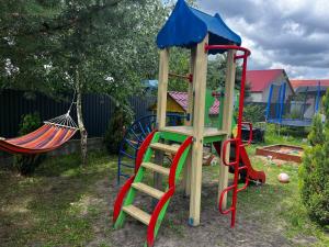 a playground with a slide and a swing at Будиночок Перший rio de pulmo in Pulʼmo