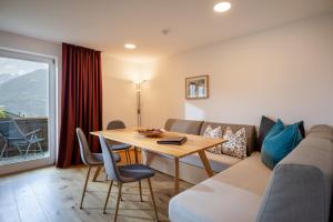 a living room with a couch and a table at Ferienwohnungen Tiroler Alpenhof in Innsbruck