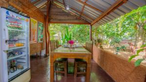 a dining room with a table and a refrigerator at Sayare Inn in Dambulla