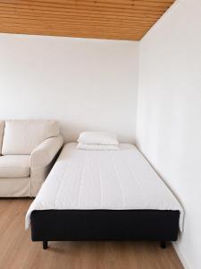 a bedroom with a bed and a couch at Villa Ralli in Jämsä