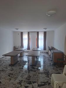 a conference room with tables and chairs and windows at Kitti Panzió in Tiszadada