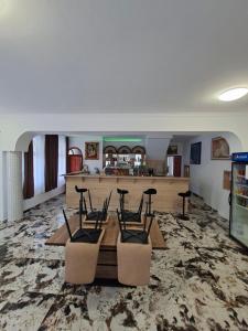 a room with a table and chairs and a counter at Kitti Panzió in Tiszadada