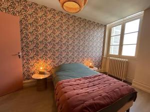 a bedroom with a bed with a red comforter and a window at Escales patrimoniales en cœur de ville in Poitiers
