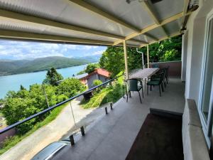 a balcony with a table and chairs and a view of a river at Villa Nena in Mavrovo