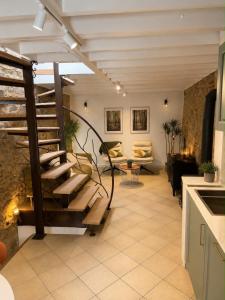 a living room with a spiral staircase in a house at La Petite Grange in Aywaille
