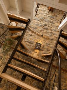 a ladder in a room with a stone floor at La Petite Grange in Aywaille