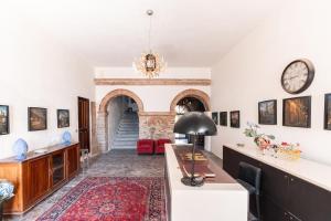 a living room with a table and a clock on the wall at Resid Enza Palazzo Sciacca in Patti