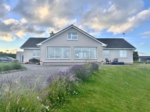 a large white house with a grass yard at Follies Garden Room in Dungarvan