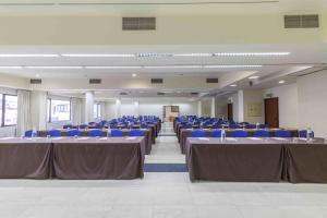 a large room with tables and blue chairs at Hotel Eurosol Leiria & Jardim in Leiria