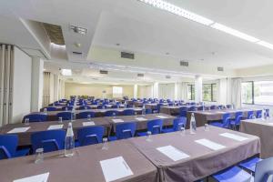 a large room with tables and blue chairs at Hotel Eurosol Leiria & Jardim in Leiria