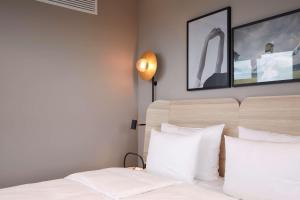 a bedroom with two beds with white pillows at Scandic München Macherei in Munich