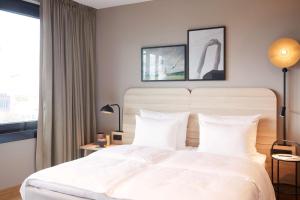 a bedroom with a white bed and a window at Scandic München Macherei in Munich +70 photos