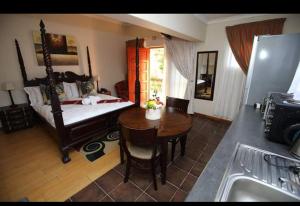 a room with a bed and a table and a kitchen at The Rest Place B&B in East London