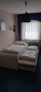 two twin beds in a bedroom with a window at Bungalow Au in Illertissen