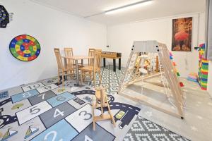 a room with a play room with a table and chairs at Ausblickhof Ferienwohnung in Egg