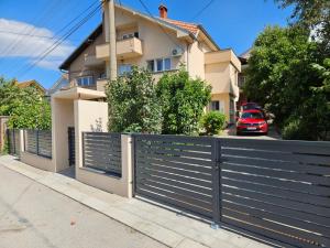 a black fence in front of a house at Apartmani Bambi 2 in Soko Banja