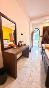 a bathroom with a large mirror in a room at Secret Garden Beach Hotel in Trincomalee