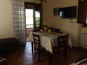 a dining room with a table with chairs and a television at PanElios Borgo Vacanze in Città della Pieve