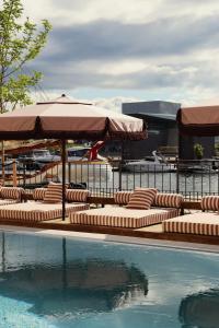 a row of lounge chairs with umbrellas next to a swimming pool at Admiral Hotel Copenhagen in Copenhagen