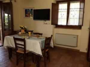 a dining room with a table with chairs and a television at PanElios Borgo Vacanze in Città della Pieve