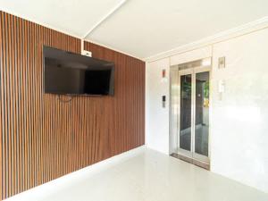 a living room with a television on a wall at Hotel Elite inn in Thanjāvūr