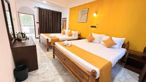 a hotel room with two beds and a television at Secret Garden Beach Hotel in Trincomalee